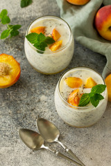 Natural detox, fruit dessert, healthy dieting concept. Peach Yogurt smoothie or milk shake with chia seeds in glass jar on a stone concrete worktop.
