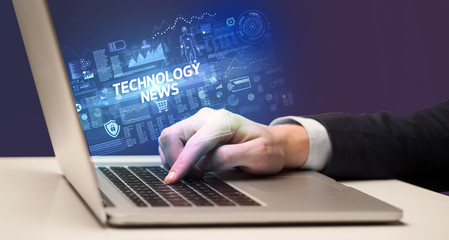 Fototapeta na wymiar Businessman working on laptop with TECHNOLOGY NEWS inscription, cyber technology concept
