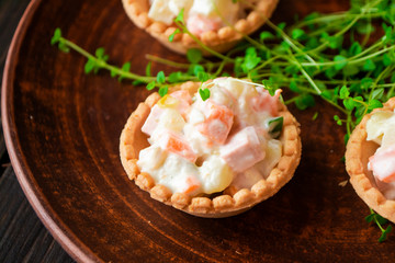 Savory tartlets made from puff pastry, filled with a creamy chicken, asparagus and carrot sauce. On dark ceramic plate
