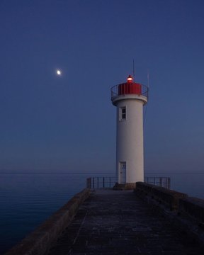 lighthouse at night with moon in Bretagne, France