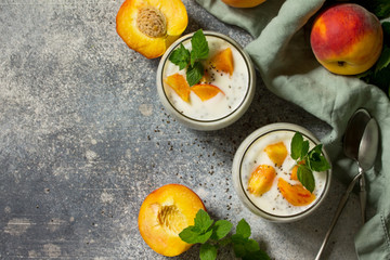 Natural detox, fruit dessert, healthy dieting concept. Peach Yogurt smoothie or milk shake with chia seeds in glass jar on a stone concrete worktop. Top view flat lay background. Copy space.