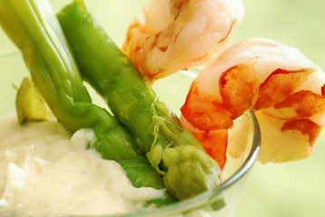 Close-up at asparagus, shrimps and cream served in small verrine glass.