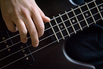 Bass guitar player hand closeup, lesson and practice theme. Playing on bass electric guitar, live...