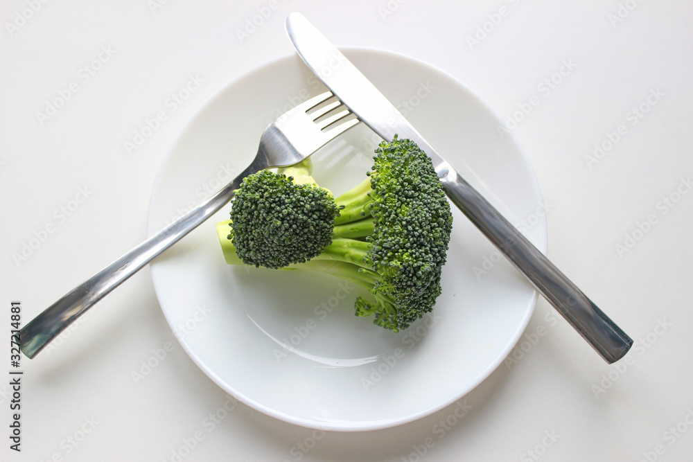 Wall mural fresh broccoli piece on plate on white background