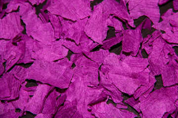 Pieces of crumpled paper on a black background. The texture of the corrugated paper. Рieces of purple paper