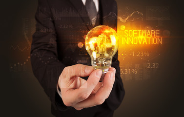 Businessman holding lightbulb with SOFTWARE INNOVATION inscription, Business technology concept