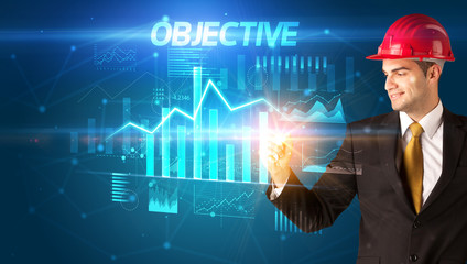 Handsome businessman with helmet drawing OBJECTIVE inscription, architecture business plan concept