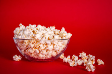 Fototapeta na wymiar Delicious fresh popcorn in a bowl on red background