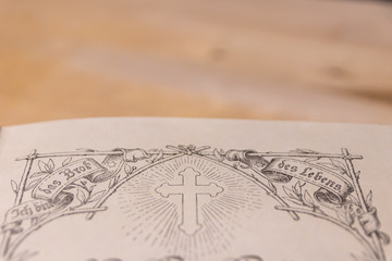 Kreuz einer geöffneten antiken Lutherbibel zeigt die evangelische Kirche und Übersetzung von...