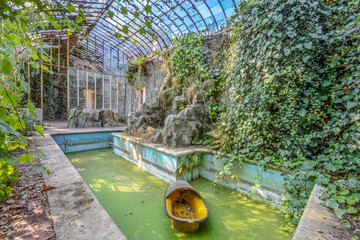 Serre en verre avec une barque jaune dans une piscine 
