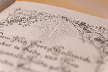 Kreuz einer geöffneten antiken Lutherbibel zeigt die evangelische Kirche und Übersetzung von...