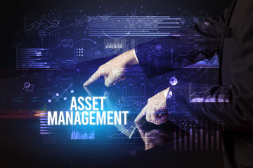 Businessman touching huge screen with ASSET MANAGEMENT inscription, cyber business concept