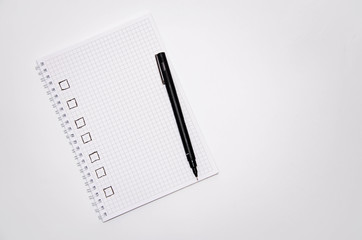 Check list. Square items are empty and checked with a tick. Squared notebook with black pen on a white background. Record ideas, notes, plans, tasks.  Copy Space