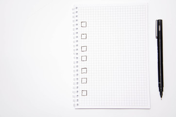 Check list. Square items are empty and checked with a tick. Squared notebook with black pen on a white background. Record ideas, notes, plans, tasks.  Copy Space