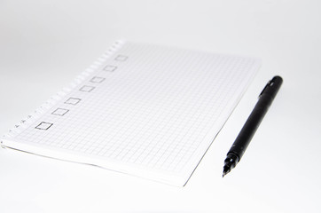 Check list. Square items are empty and checked with a tick. Squared notebook with black pen on a white background. Record ideas, notes, plans, tasks.  Copy Space