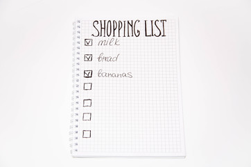 Shopping list. Squared notebook with black pen on a white background. Record ideas, notes, plans,...