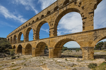 Fototapeta na wymiar Pont du Gard is one of the most impressive samples of Roman architecture. Scenic view of ancient Roman aqueduct Pont du Gard over Gardon river near Nimes, Gard, Provence, France