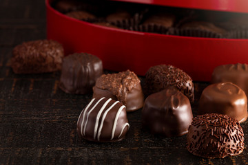 Red Heart Box of Chocolate Truffles on a Rustic Wooden Table