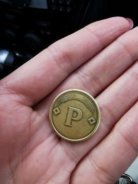 A car Park token in my hands. Paid Parking near a restaurant in the city