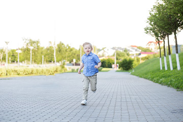 Child boy runs fast through the park. The concept is back to school, care and play.