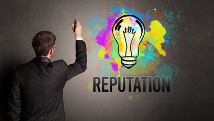 businessman drawing colorful light bulb with REPUTATION inscription on textured concrete wall, new...