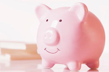 Close uup piggy bank against US Dollar bills as symbol of wealth and power. Horizontal image.