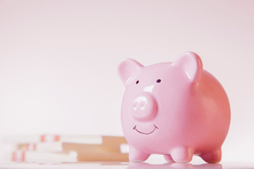Piggy bank against money backgrouund as symbol of profit and success