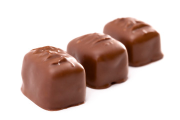 Three Milk Chocolate Truffles in a Row on a White Background