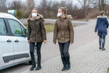 Menschen mit Atemmaske auf der Straße in Deutschland wegen Coronavirus