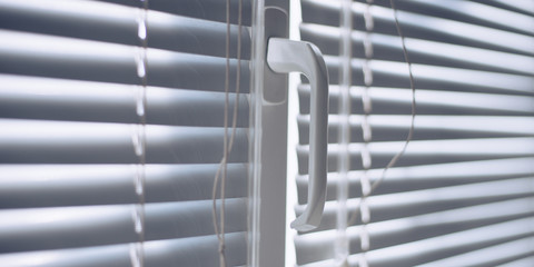 Closed horizontal blinds with rope and handle. Perspective view, closeup