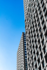 many Windows of a skyscraper. brick walls with Windows. Texture of a skyscraper against a blue sky