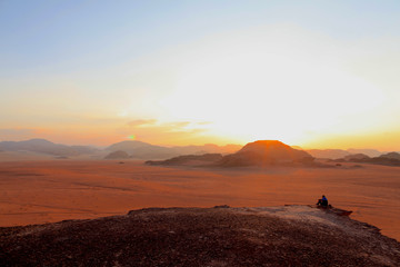 silhouette of man on top of the mountain at sunset  on the Wadi Rum red desert in Jordan