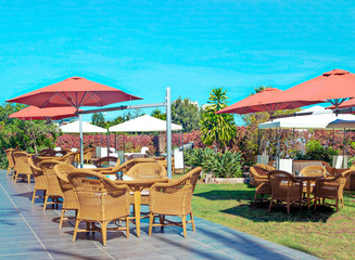 Tables and chairs in a garden without people