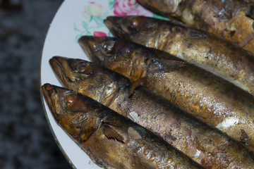 Smoked fresh fish mackerel lies hot on a ceramic plate