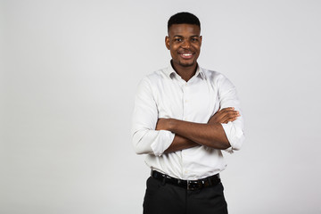 African american man in strict black pants and a white shirt on a white background. Smiling positive emotions.