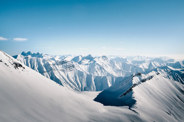 Snowy mountains in nice sun day. Caucasus Mountains, Georgia. View from ski resort Gudauri.