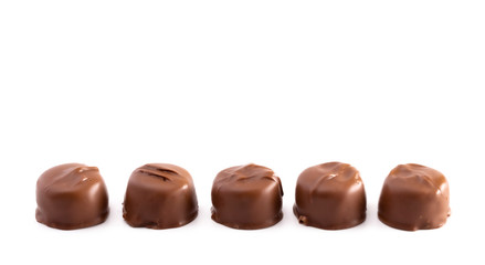 Five Milk Chocolate Truffles in a Row on a White Background