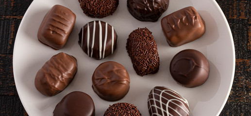 Assorted Chocolate Truffles on a Rustic Wooden Table in a Dark Environment