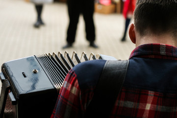 a street musician plays the harmonica