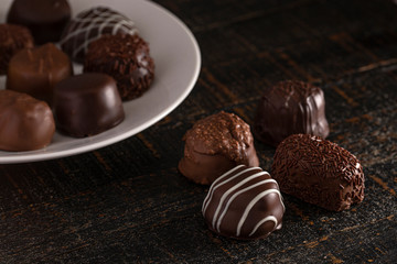 Assorted Chocolate Truffles on a Rustic Wooden Table in a Dark Environment