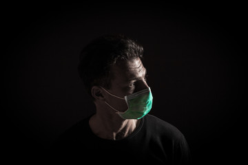 Portrait of  sick caucasian man with medical mask. Coronavirus Covid-19 concept. Black background 