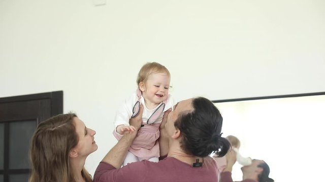 Close up face of laughing cheerful playful family having fun together. Carefree parents mother father and cute little baby smiling playing having positive emotion 4k footage