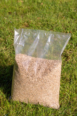 Foil packaging with grass seeds. Sowing grass, setting up a lawn.