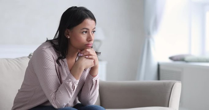 Sad thoughtful young african woman thinking of problems sit alone