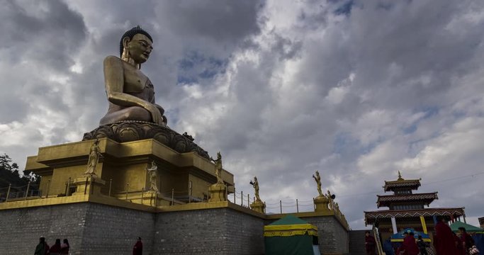 The Buddha Dordenma statue on the hills around Thimphu, Bhutan, Himalaya. Time lapse at the kingdom of Bhutan. The golden Buddha during a prayer ceremony for the Thailand king in 2017. Monk passing by