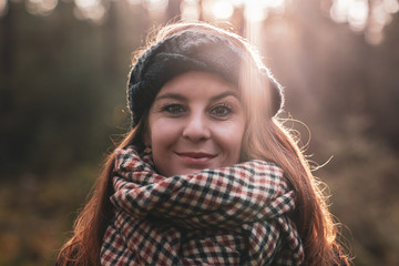 Woman standing in the sunshine under the cover of the forest.