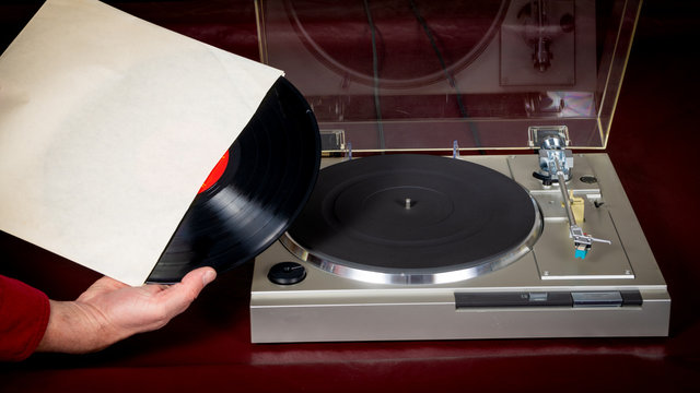 Vinyl record is removed from the jacket with turntable