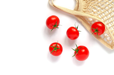 Top view of five fresh red tomatoes with green cuttings and a string bag made of natural material, on a white background. Isolated.