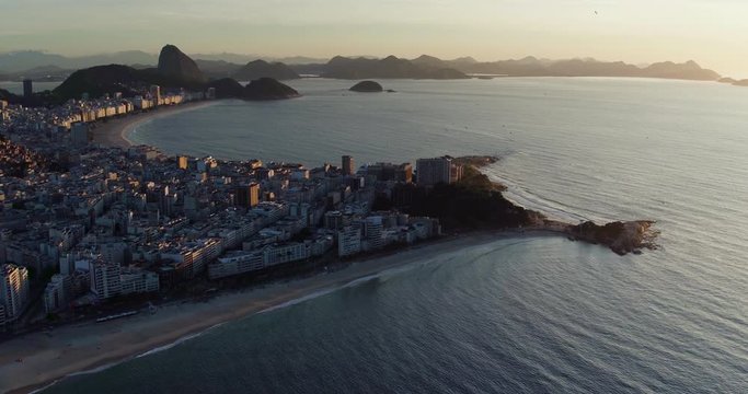 Aerial wide angle panning view of famous Copacabana Beach at sunrise, Rio de Janeiro. Sugarloaf Mountain in the background.