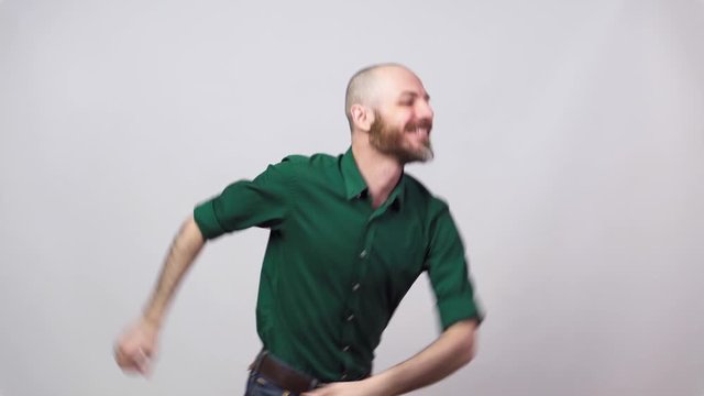 Happy bearded bald man dancing solo jazz on white background.